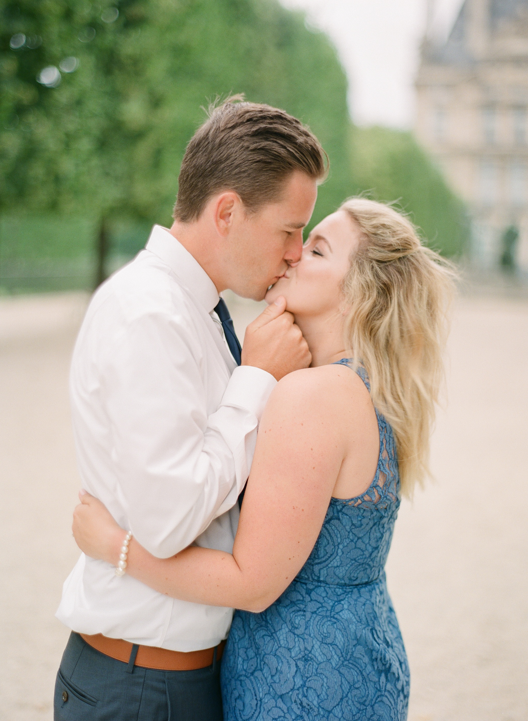 Paris Honeymoon Photographer | France Wedding Photographer | Paris Film Photography | Molly Carr Photography | Couple Kissing At Engagement Photos | Jardin Des Tuileries Engagement Session | Girl In Blue Lace JCrew Dress