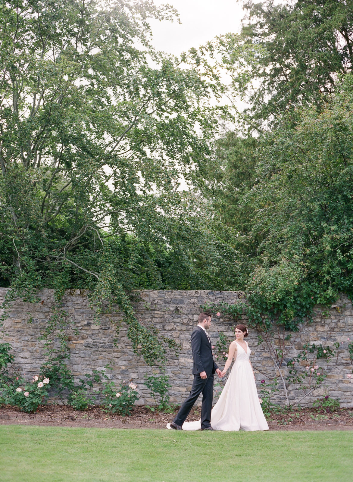 Ireland Film Photographer | Molly Carr Photography | Bride and Groom Walking Through Mount Juliet Estate Walled Garden