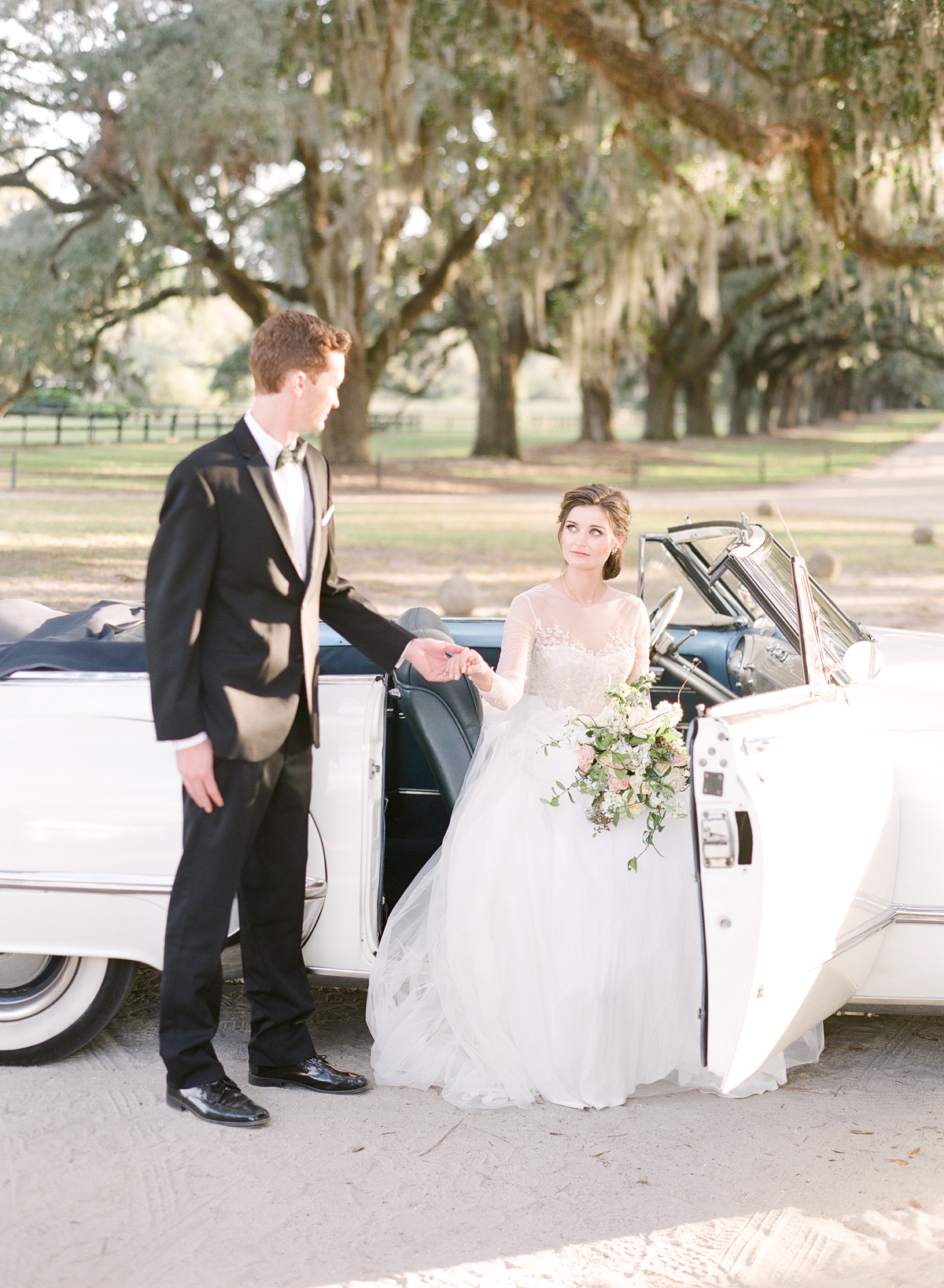 Fine Art Wedding Photographer | Molly Carr Photography | Magnolia Rouge Feature | Boone Hall Wedding | Boone Hall Plantation Wedding Photography | Bride and Groom Getting Out of Vintage Convertible | Groom Helping Bride Out of Car | Wedding Getaway Car | Vintage Getaway Car | Emily Kotarski Wedding Dress