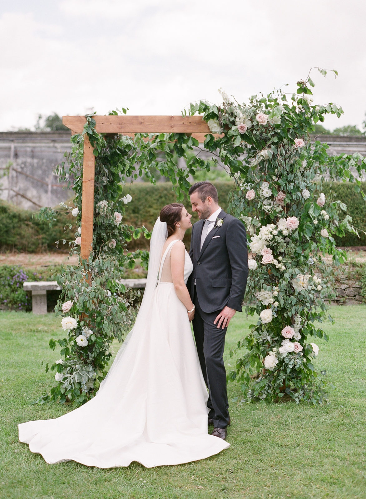 Ireland Film Photographer | Molly Carr Photography | Bride and Groom in Front of Flower Arch at Mount Juliet Estate